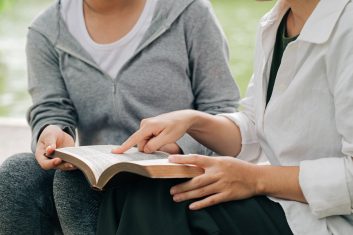 Two women studying and  talking about the bible .